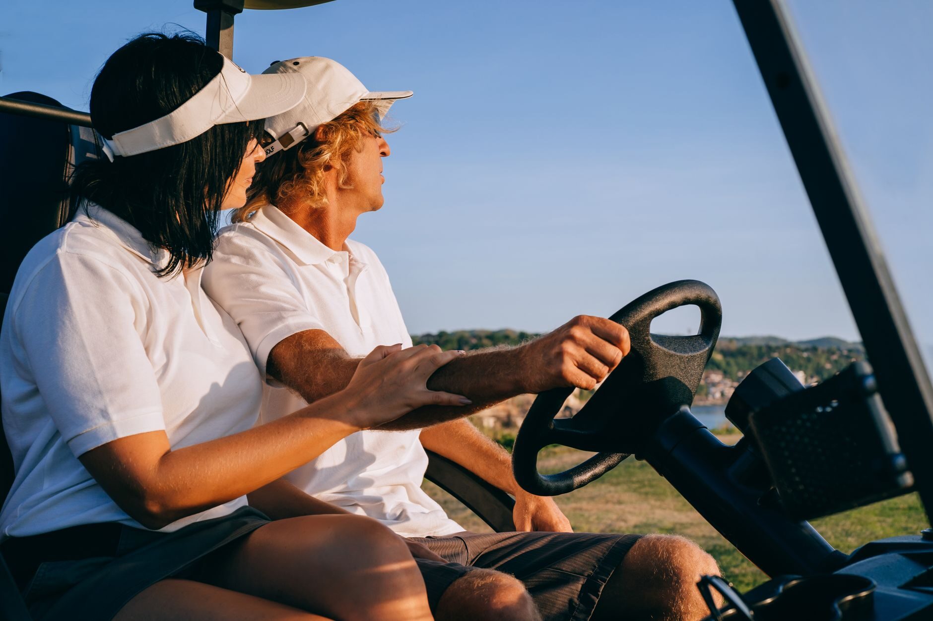 Couple cruising a Gulf Coast neighborhood in an LSV electric golf cart