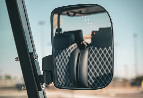 Passenger-side folding mirror on EPIC E40L showing stitched seat reflection
