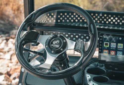 Steering wheel and dash of EPIC E40L with carbon fiber finish, touchscreen display, and built-in cup holders