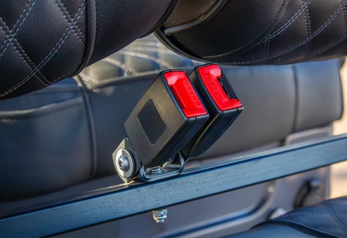 Close-up of 3-point retractable seat belts on EPIC E60 diamond-stitched rear seats