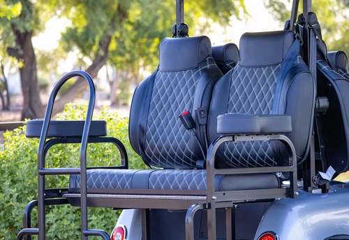 Rear-facing view of EPIC E60L 6-seat golf cart with fold-down cargo seat and diamond-stitched black upholstery