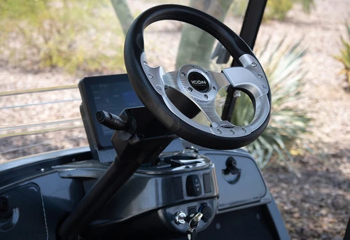 Side view of ICON i60 six-passenger golf cart in silver with black roof and chrome wheels