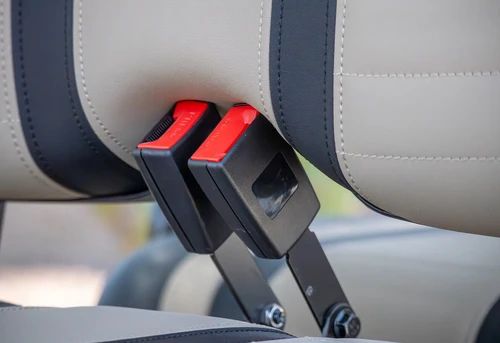 Close-up of dual red push-button seatbelts on ICON i60 rear seats