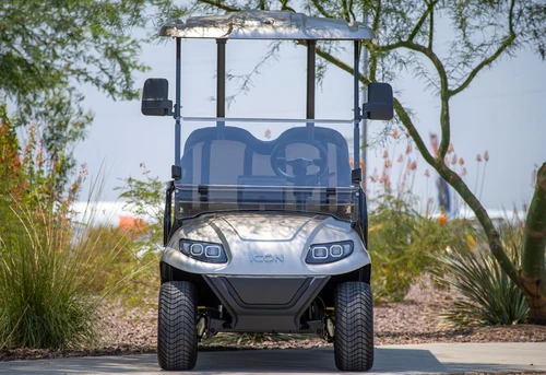 ICON i60 golf cart parked in residential area with passengers riding comfortably