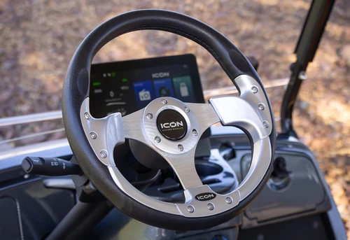 Steering wheel and multimedia dash of 2025 ICON i60L showing aluminum spokes and touchscreen controls